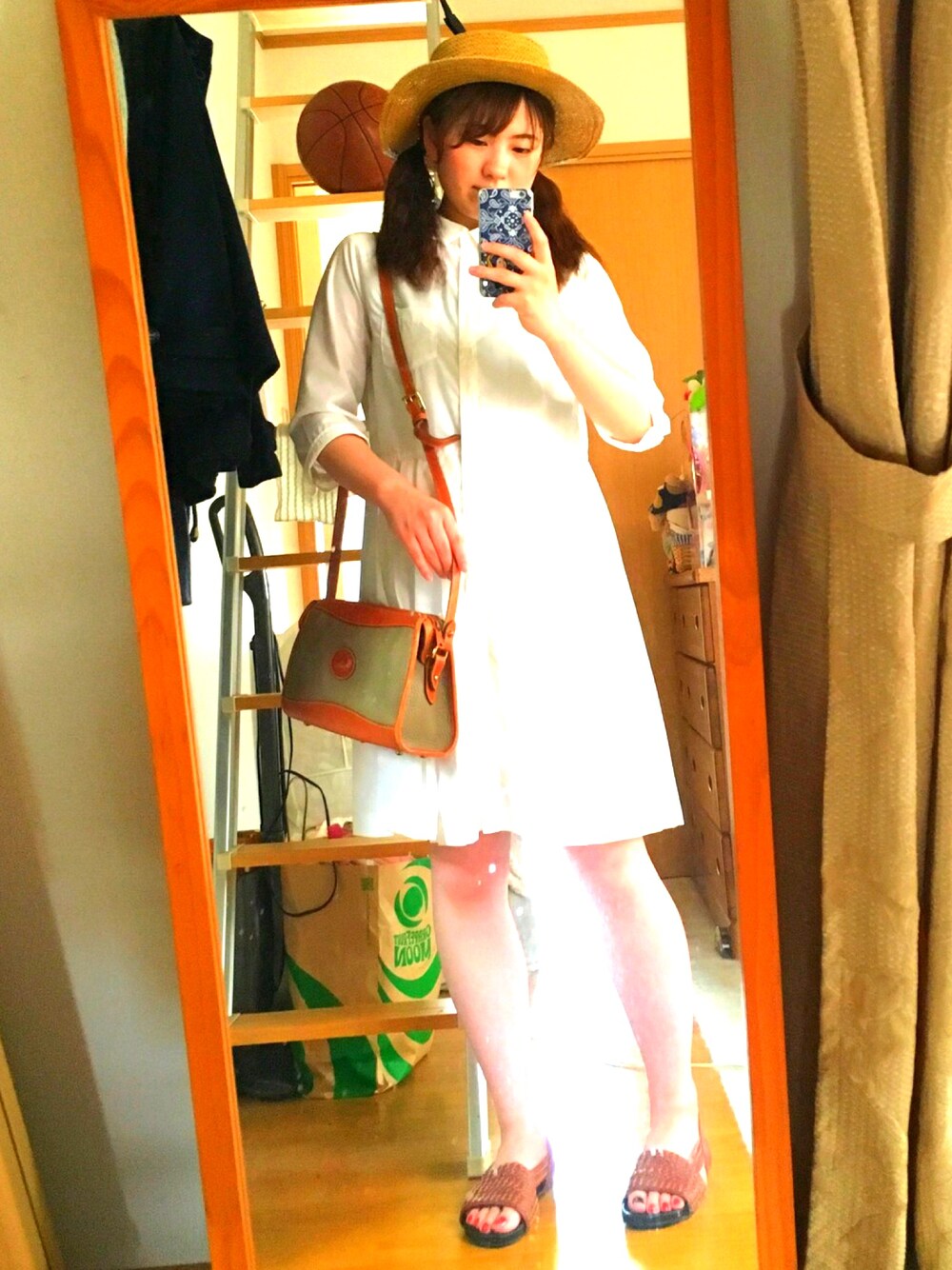 ホワイト系のシャツワンピース、グリーン系のショルダーバッグ、ブラウン系のサンダルを着用したレディースの夏コーディネートの1枚目の写真