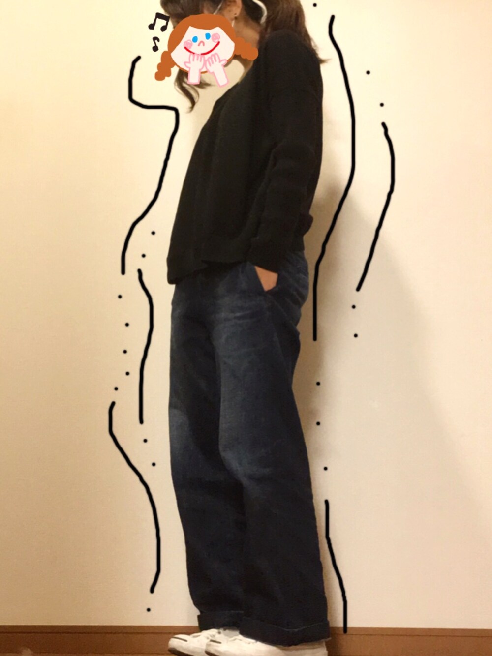ブラック系のニット/セーター、ブルー系のデニムパンツ、ホワイト系のスニーカーを着用したレディースの秋コーディネートの1枚目の写真