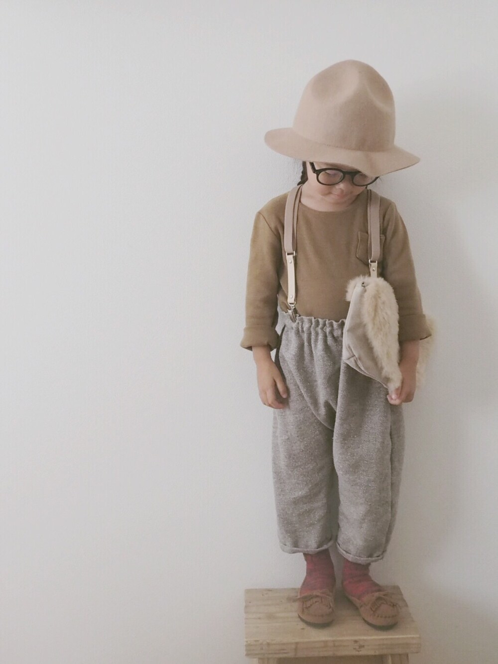 イエロー系のTシャツ/カットソー、ベージュ系のクラッチバッグ、レッド系のソックス/靴下を着用したキッズの秋コーディネートの1枚目の写真