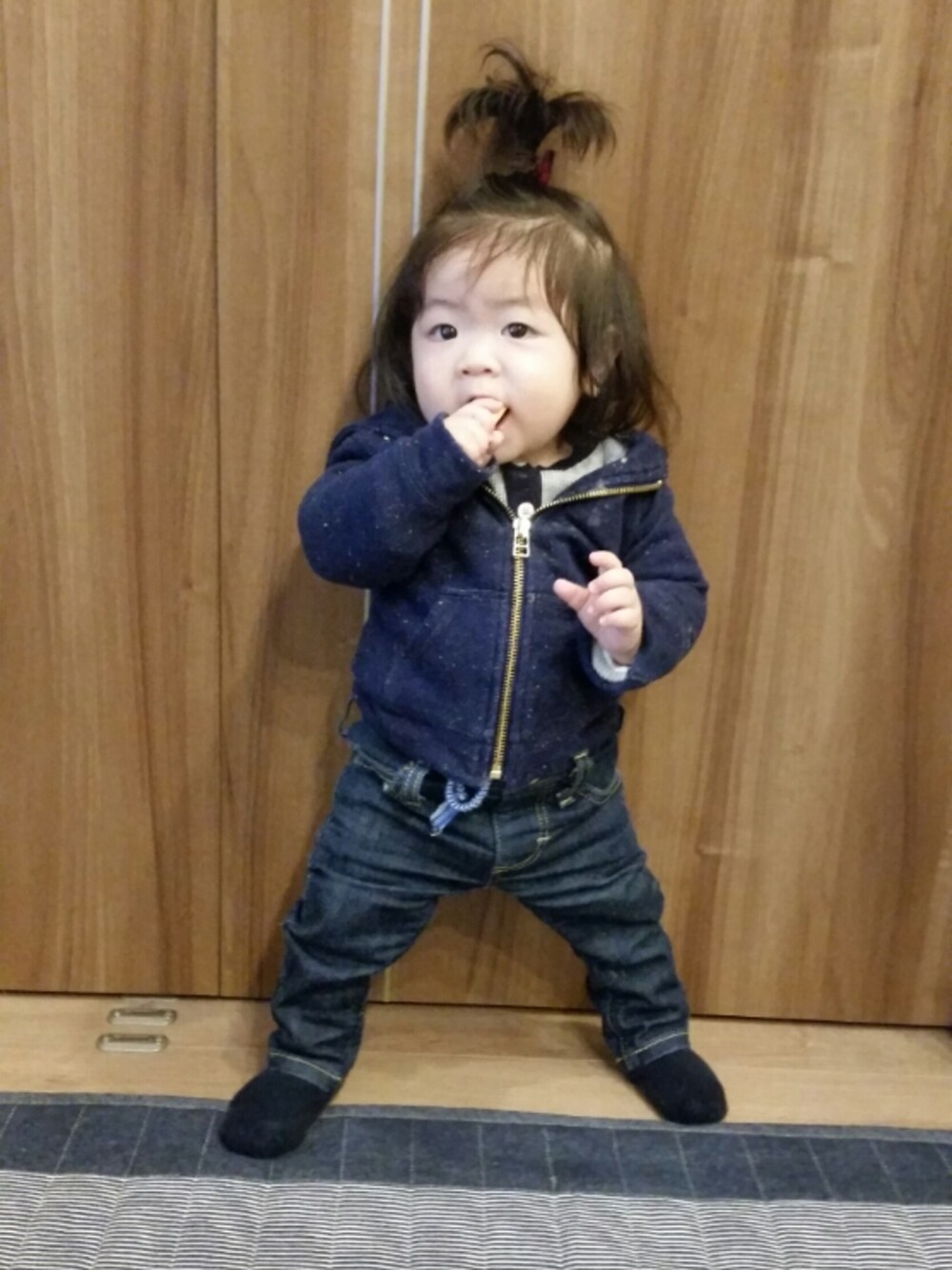 ブルー系のデニムパンツ、ブルー系のパーカー、グレー系のロンパースを着用したキッズの秋コーディネートの1枚目の写真