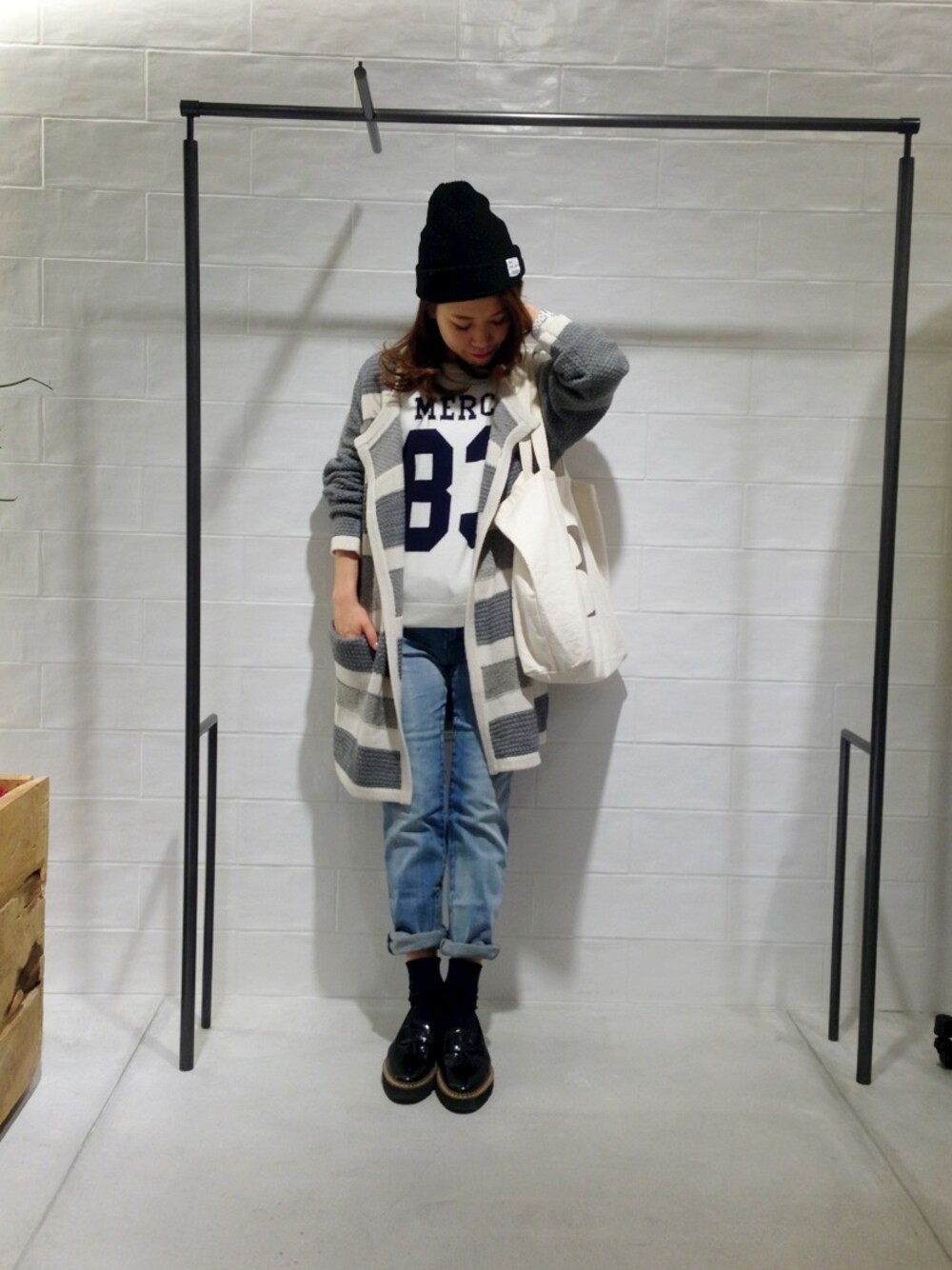 ホワイト系のカーディガン/ボレロ、ブルー系のデニムパンツ、ブラック系のパンプスを着用したレディースの冬コーディネートの1枚目の写真