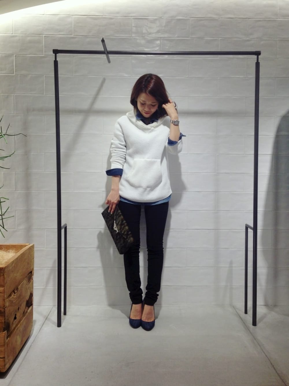 ホワイト系のパーカー、その他のクラッチバッグ、ブルー系のシャツ/ブラウスを着用したレディースの冬コーディネートの1枚目の写真