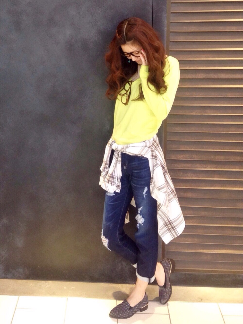 ブルー系のデニムパンツ、グリーン系のニット/セーターを着用したレディースの春コーディネートの1枚目の写真