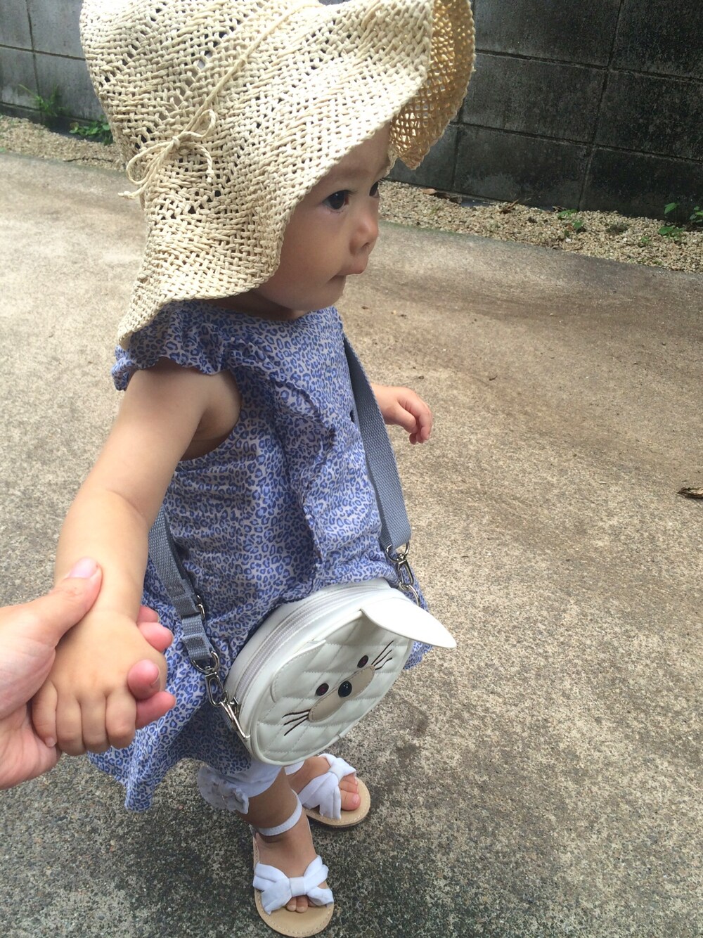 ブルー系のチュニック、ホワイト系のサンダル、ホワイト系のショルダーバッグを着用したキッズの夏コーディネートの1枚目の写真