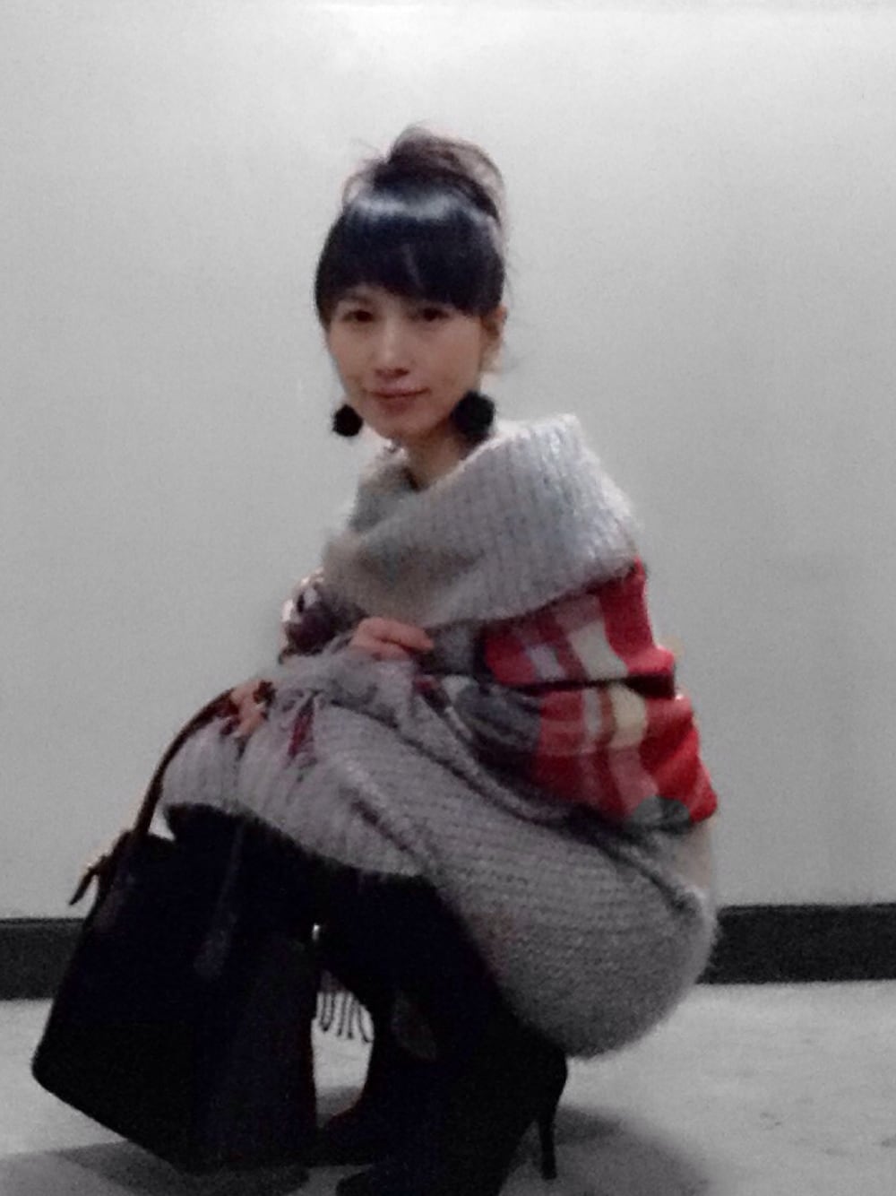 ブラック系のパンプス、ブラック系のショルダーバッグ、グレー系のワンピースを着用したレディースの冬コーディネートの1枚目の写真