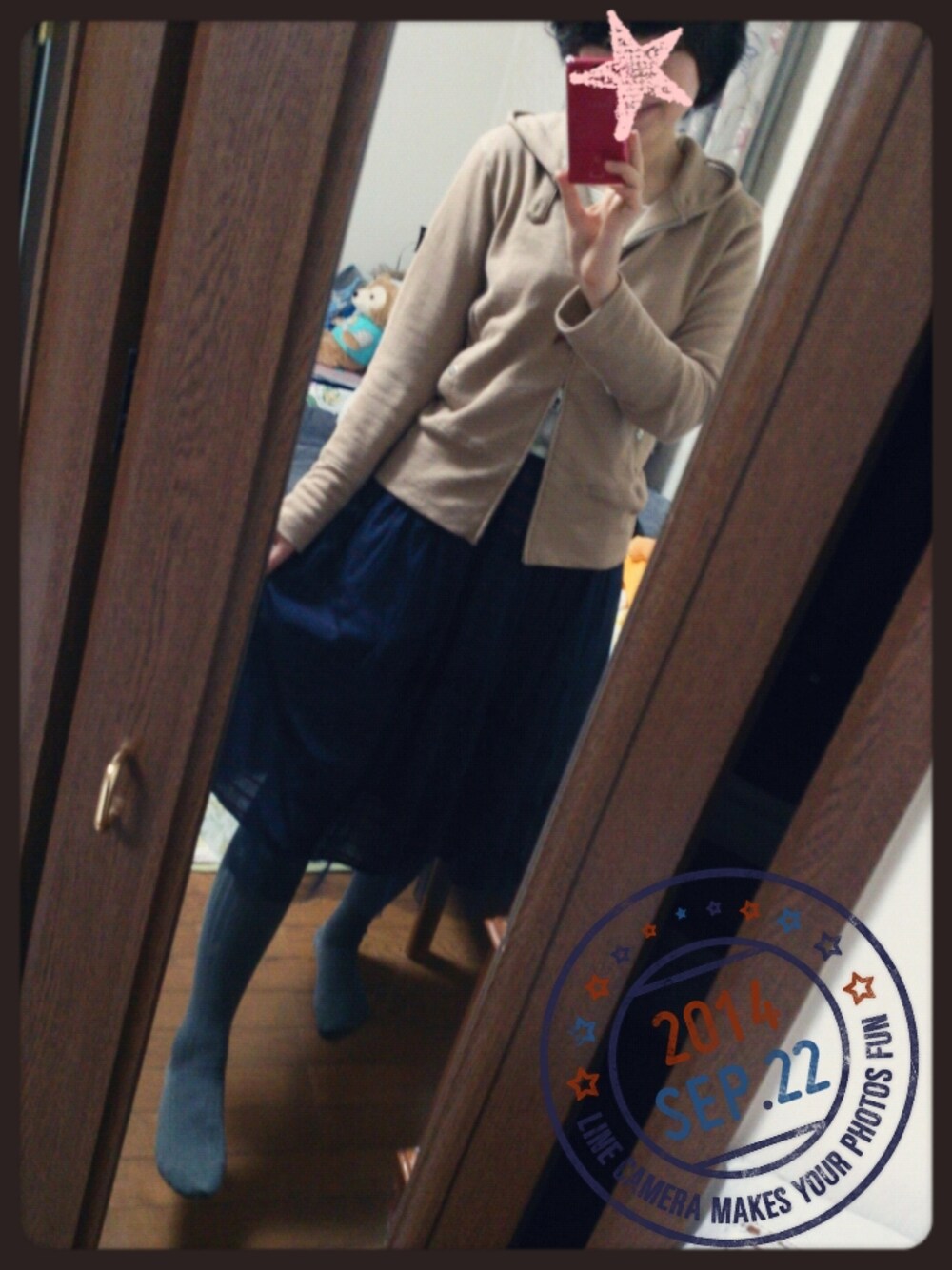 レッド系のスカート、ベージュ系のパーカーを着用したレディースの秋コーディネートの1枚目の写真