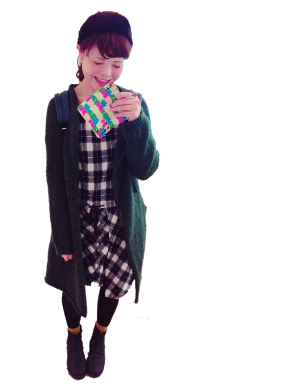 グリーン系のカーディガン/ボレロ、ブラック系のワンピース、ブルー系のバックパック/リュックを着用したレディースの冬コーディネートの1枚目の写真