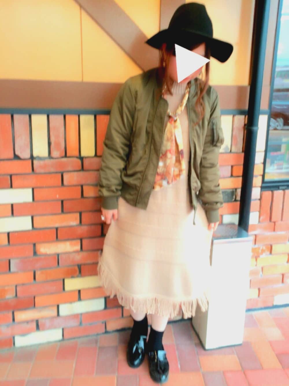 グリーン系のMA-1、ベージュ系のワンピース、ブラック系のハットを着用したレディースの冬コーディネートの1枚目の写真